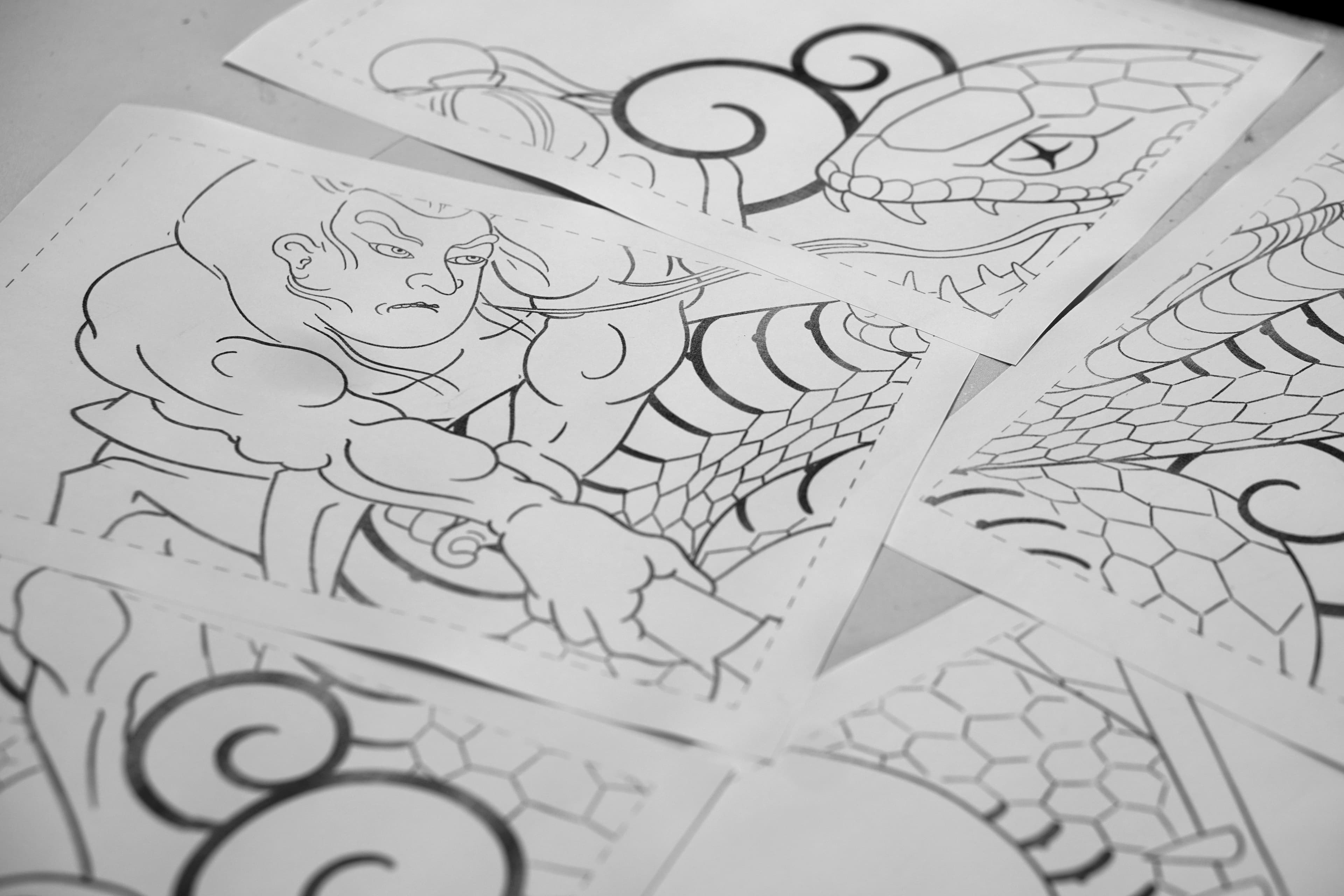 Printed tattoo stencil pages tiled across multiple sheets of paper
